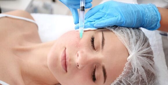 A cosmetologist performs a facial skin rejuvenation procedure with plasma